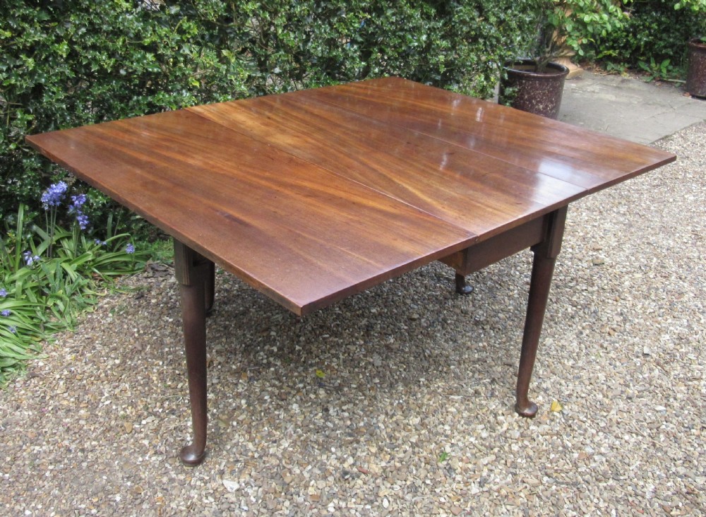 A Georgian mahogany drop-leaf dining table shown with extended leaves and tapered legs ending in pad feet. View V