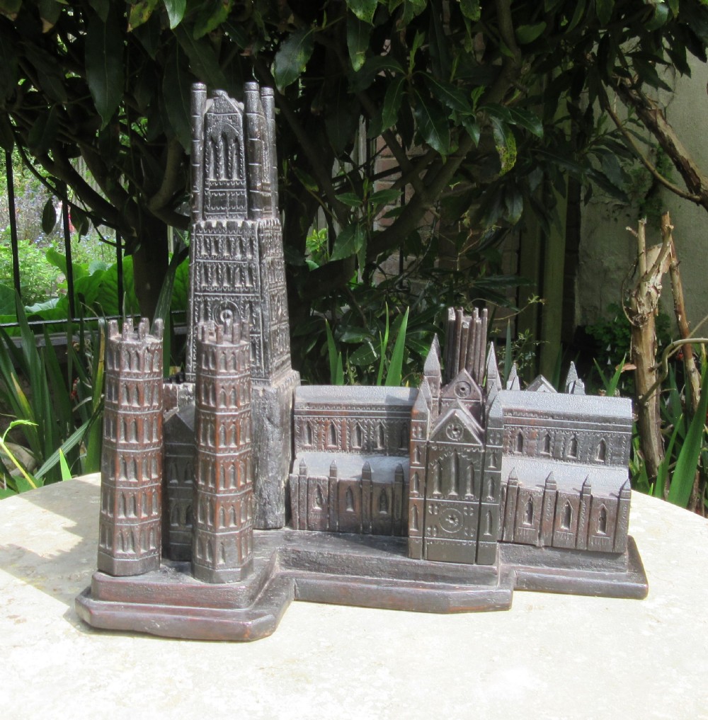 A detailed dark carved oak architectural model of Ely Cathedral featuring multi-tiered towers, lancet windows, and intricate Gothic carving. View II