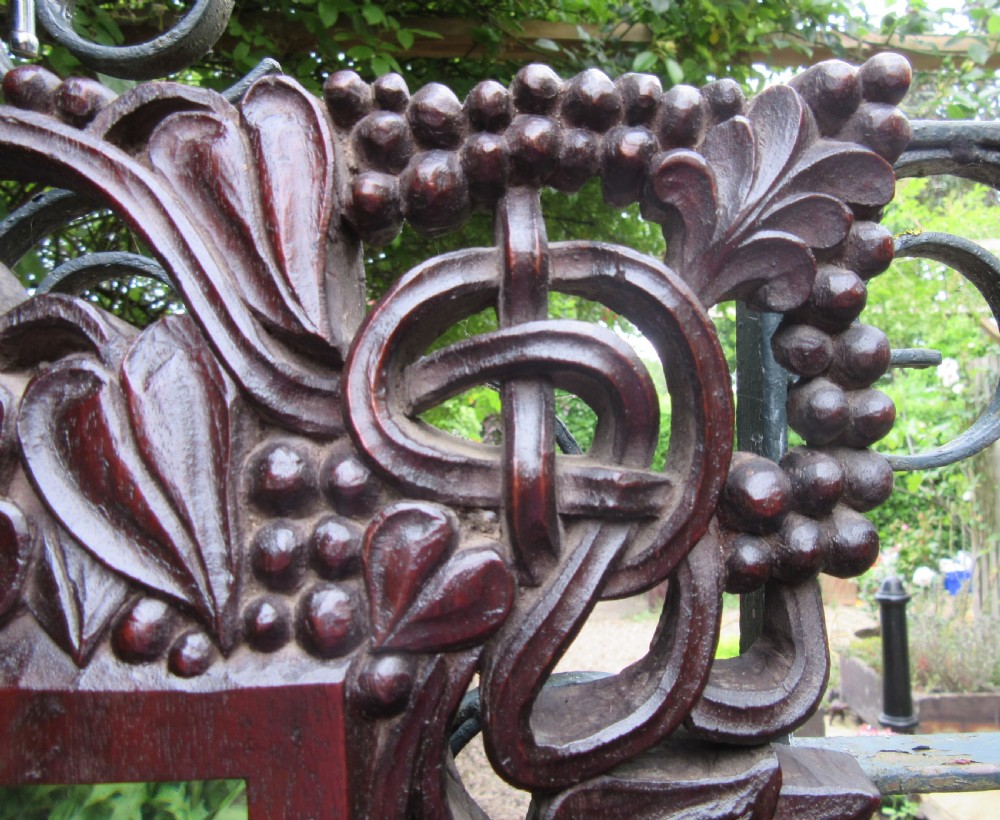 A square dark hardwood Anglo-Indian wall mirror featuring intricate pierced openwork floral and foliate hand carving surrounding a bevelled glass mirror plate. View III