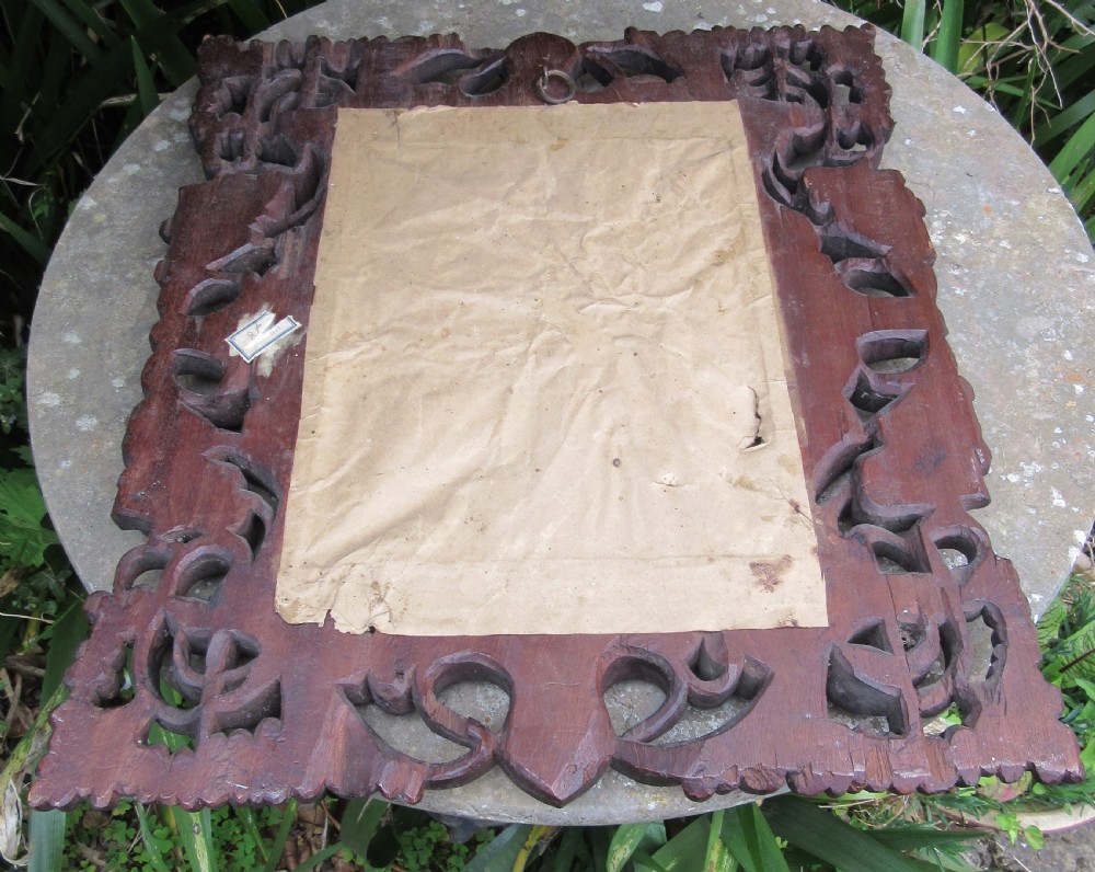 A square dark hardwood Anglo-Indian wall mirror featuring intricate pierced openwork floral and foliate hand carving surrounding a bevelled glass mirror plate. View IV