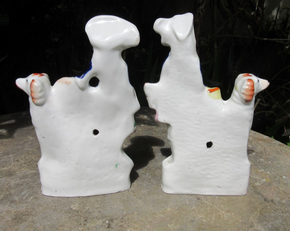 A pair of Victorian Staffordshire glazed earthenware figures depicting a male and female musician dressed in traditional attire, each accompanied by a white and orange spaniel. View III