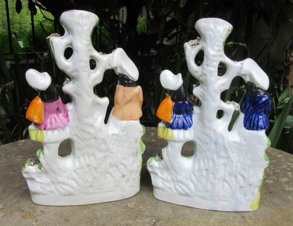 A pair of 19th-century Victorian Staffordshire earthenware spill vases featuring hand-painted figures, spaniels, and hollow tree trunk forms. View VI