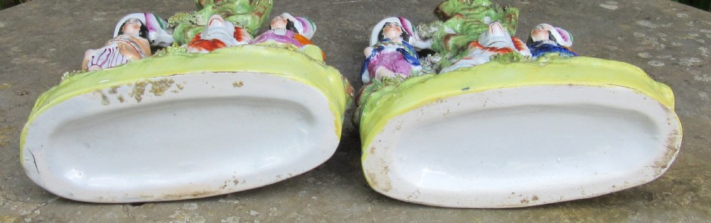 A pair of 19th-century Victorian Staffordshire earthenware spill vases featuring hand-painted figures, spaniels, and hollow tree trunk forms. View VII