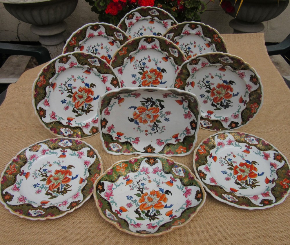 A Regency period Masons Patent Ironstone dessert service featuring hand-painted orange floral patterns and dark green gilded scalloped borders.