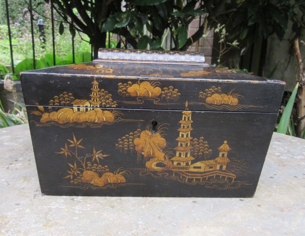 A black lacquered sarcophagus-shaped Regency tea caddy decorated with gilded Chinoiserie landscapes, pagodas, and foliage.