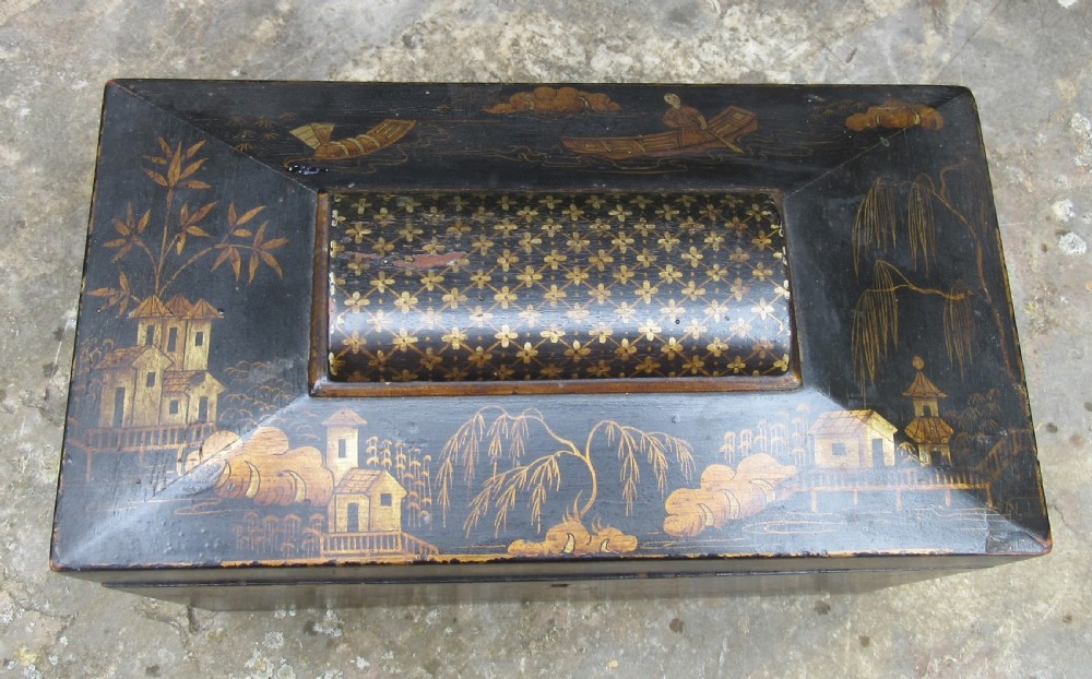 A black lacquered sarcophagus-shaped Regency tea caddy decorated with gilded Chinoiserie landscapes, pagodas, and foliage. View II