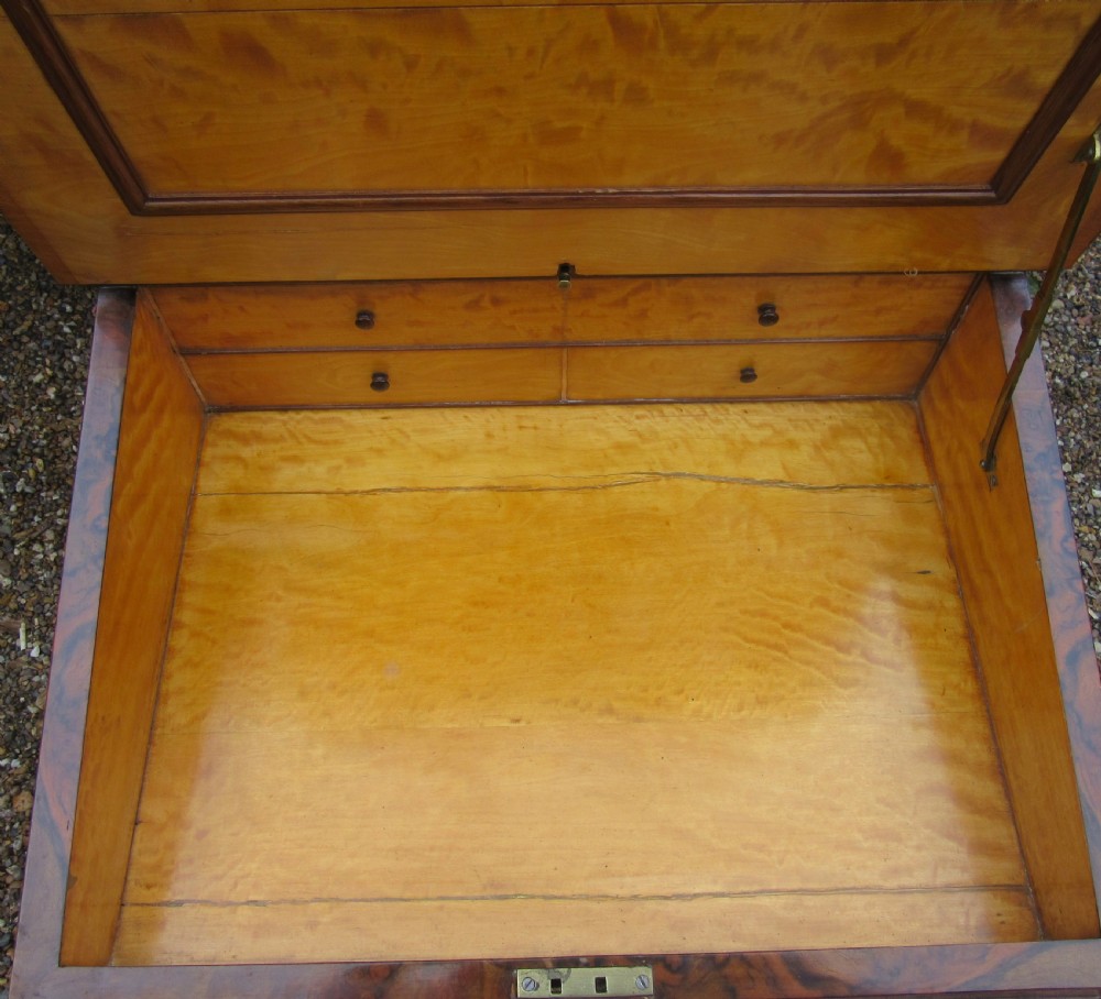 Victorian burr walnut davenport desk featuring a sloped leather writing top, carved scroll supports, side cupboard door, and brass gallery. View IX