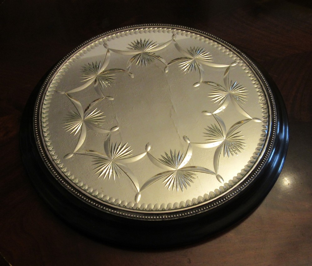 A circular Victorian mirrored table plateau featuring wheel-cut starburst patterns framed by a beaded metal rim on a turned ebonised wood base. View III