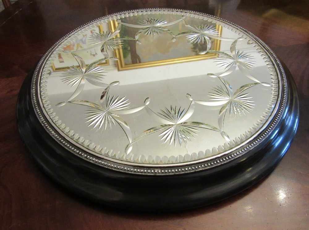 A circular Victorian mirrored table plateau featuring wheel-cut starburst patterns framed by a beaded metal rim on a turned ebonised wood base. View VII