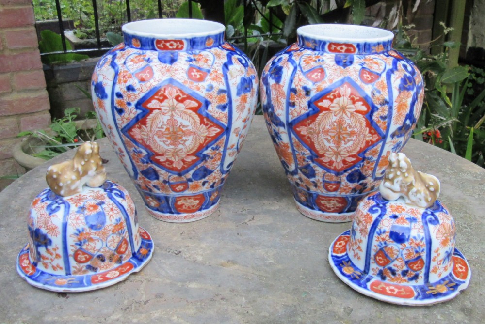 A pair of Victorian porcelain covered vases decorated with cobalt blue and rust red floral patterns topped with foo dog finials. View IV