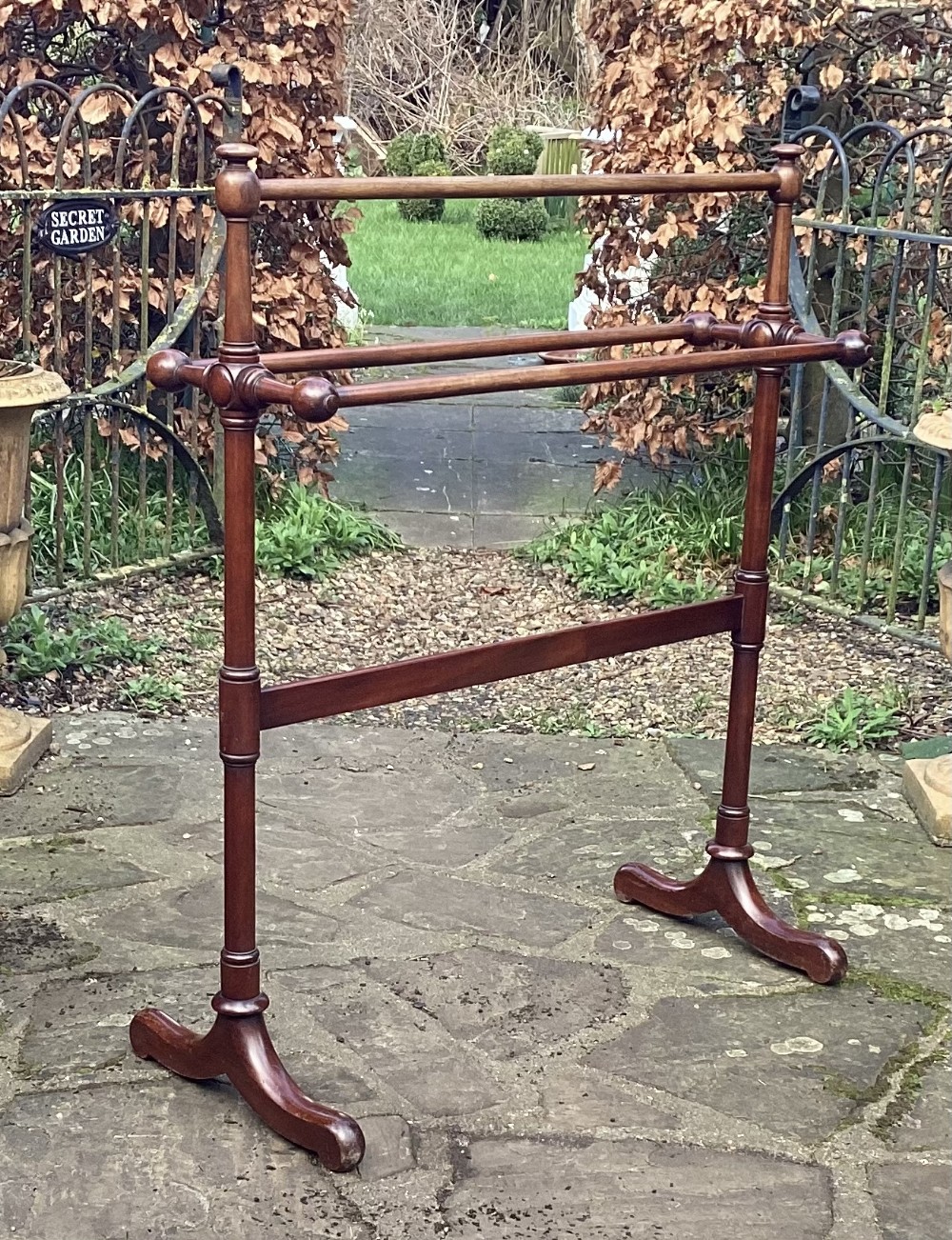 A freestanding early nineteenth-century mahogany towel rail with turned rails, side supports, and arched trestle feet.