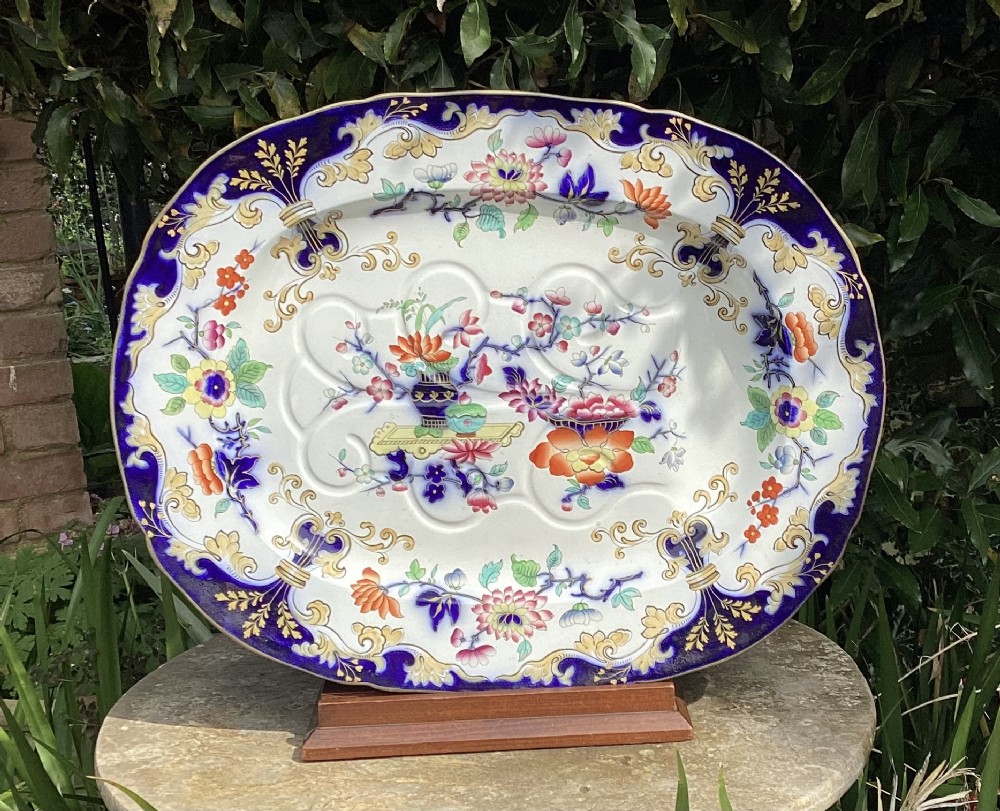 A large oval Victorian Minton ceramic well and tree serving platter featuring a cobalt blue and gold scroll rim with hand-coloured floral chinoiserie motifs in the centre.