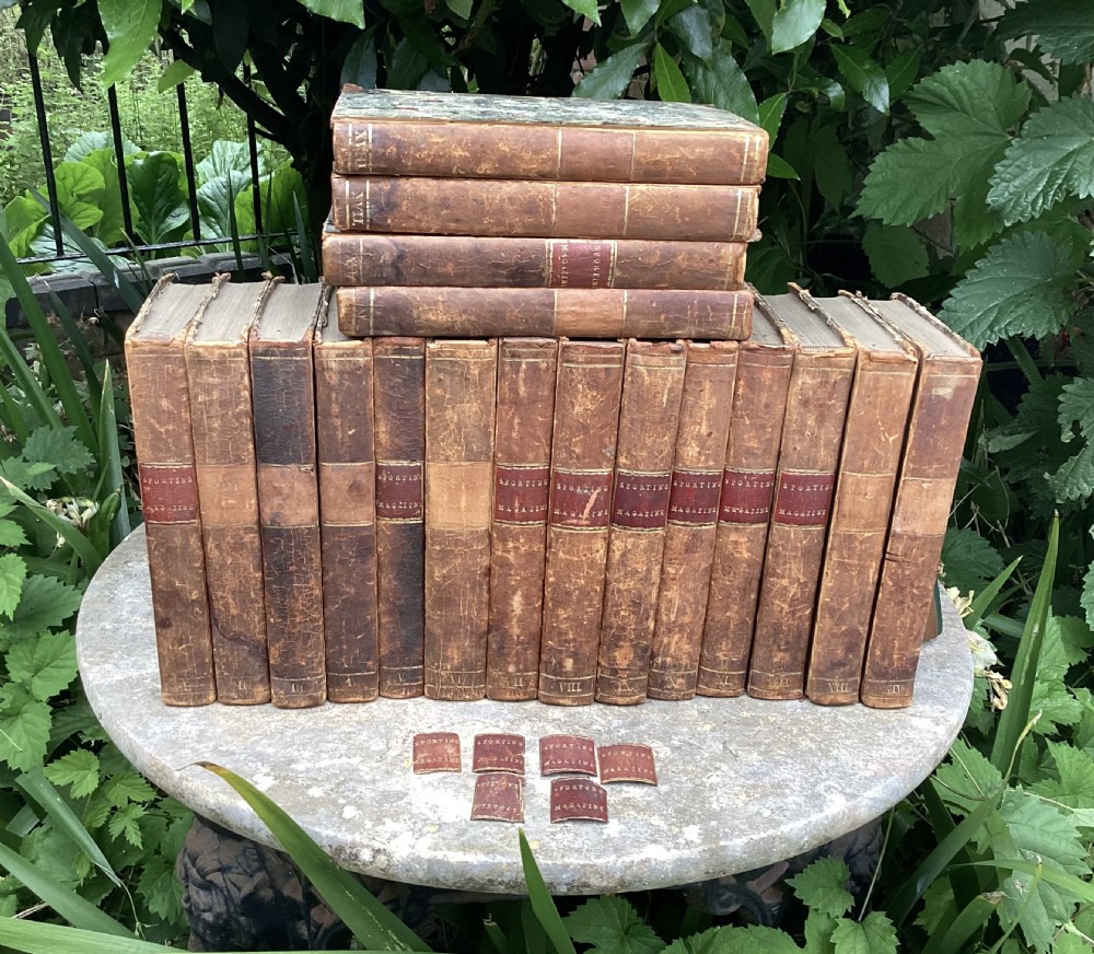 An eighteen-volume collection of Georgian leather-bound books featuring gilt-tooled lettering and red spine labels.