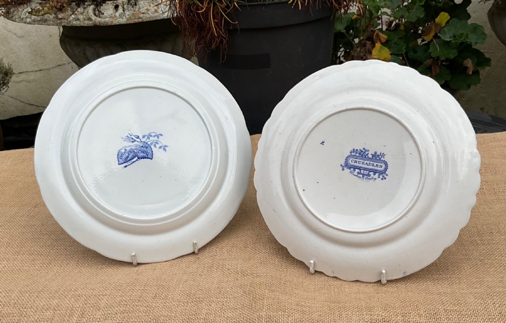 A group of six early 19th-century Staffordshire blue and white transferware ceramic plates displaying pastoral, coastal, and floral patterns with scalloped borders. View V