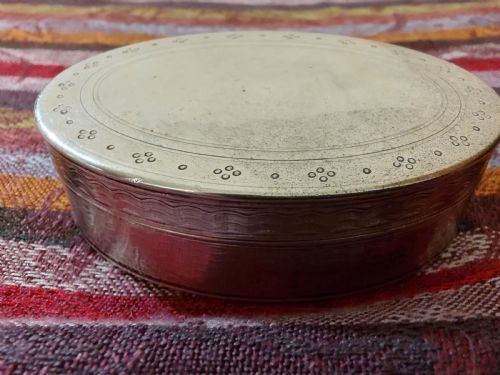 fig 1. An oval Edwardian silver snuff box with an engraved dot pattern along the edge of the lid.
