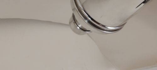 fig 1. A polished silver-plated Art Deco three-piece cocktail shaker with ribbed collar details resting on a textured fabric surface.