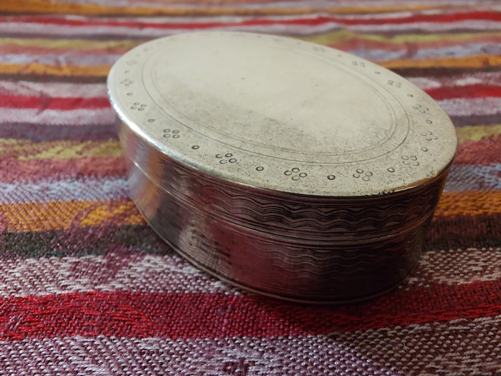 An oval Edwardian silver snuff box with an engraved dot pattern along the edge of the lid. View III