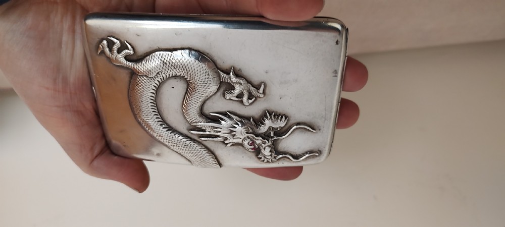A rectangular silver Art Deco cigarette case featuring a detailed raised dragon motif across the front surface. View XIII