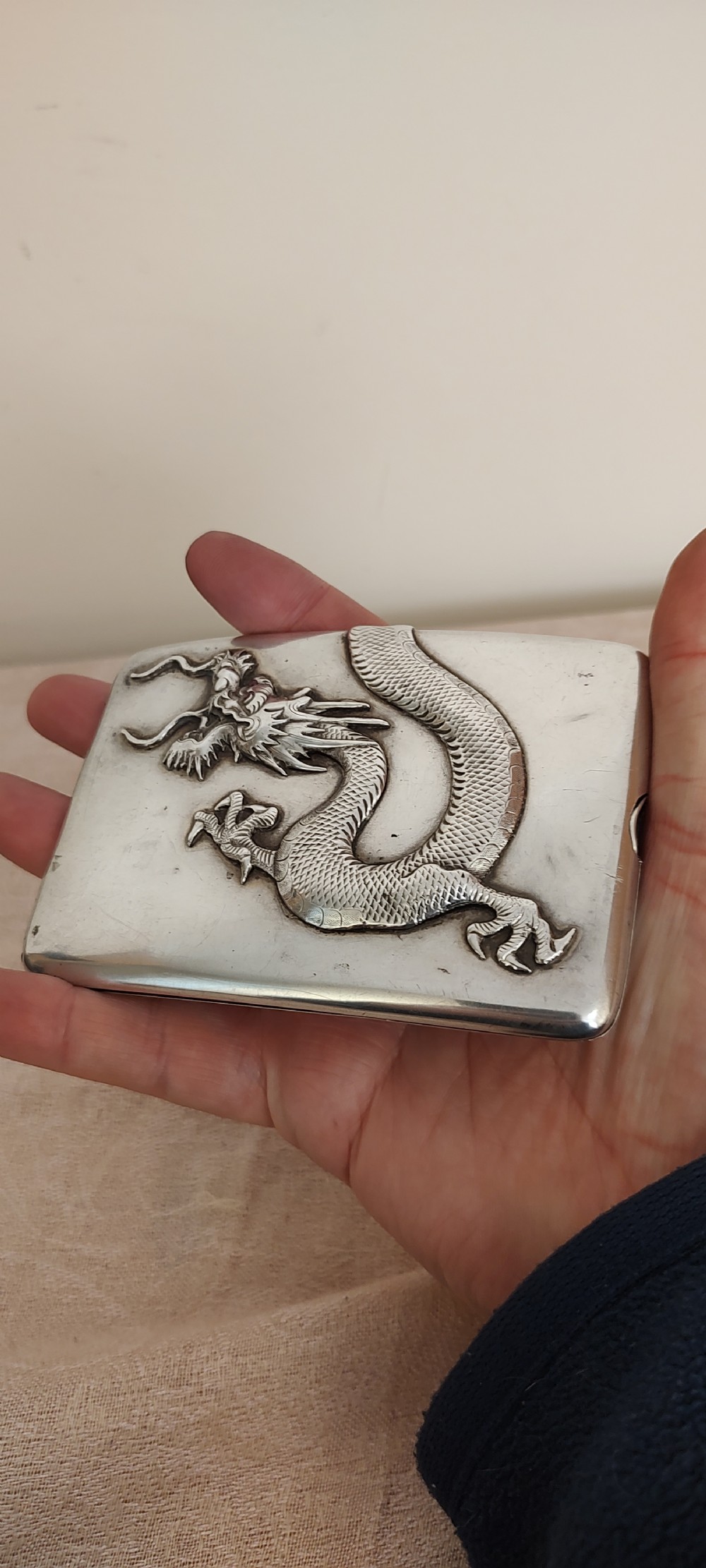 A rectangular silver Art Deco cigarette case featuring a detailed raised dragon motif across the front surface. View XV
