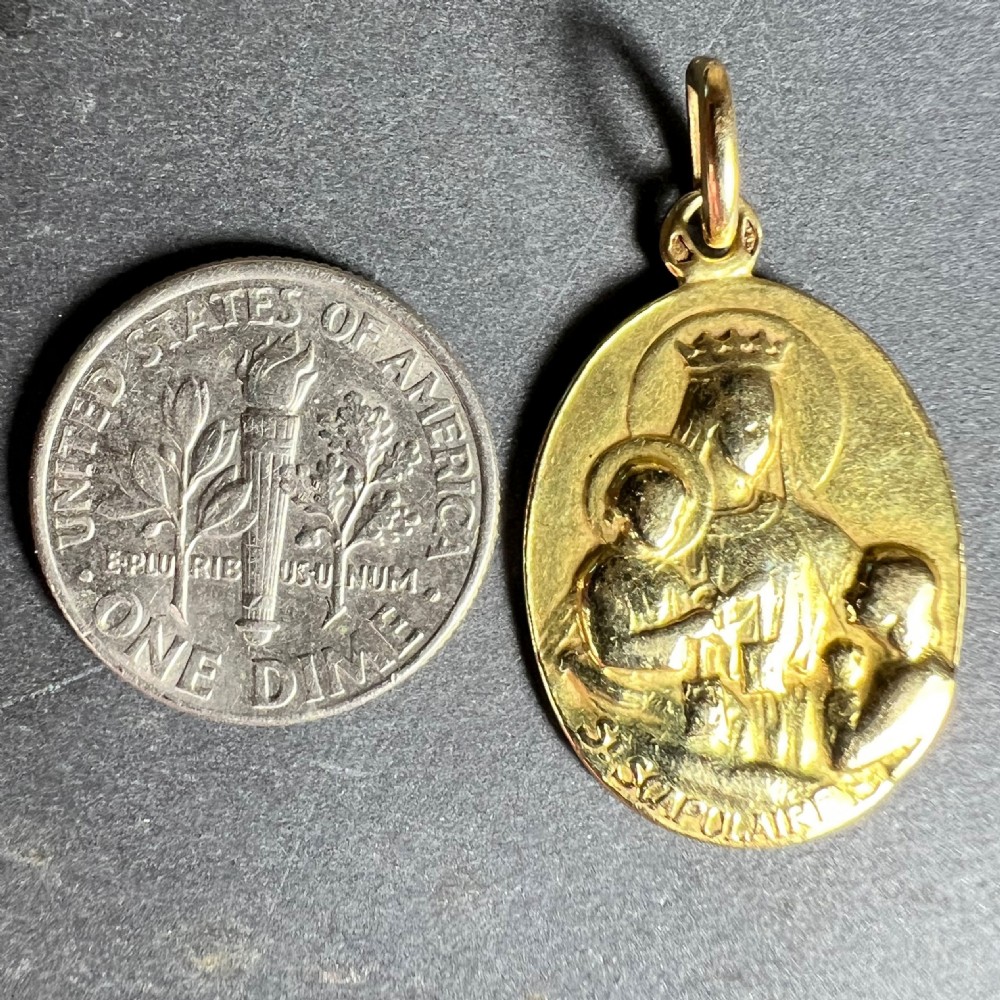 An oval 18-carat yellow gold religious medal featuring a relief depiction of the Madonna and Child inscribed St Scapulaire. View X