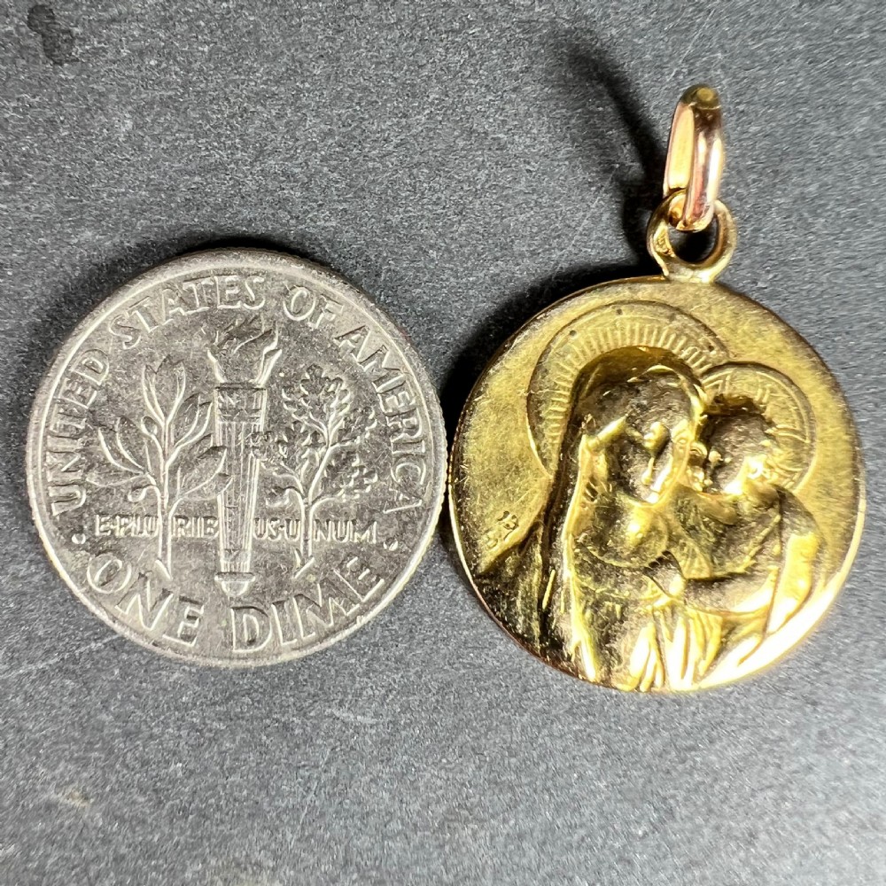 A circular 18ct yellow gold medal pendant featuring a bas-relief depiction of the Madonna and Child with halos. View X