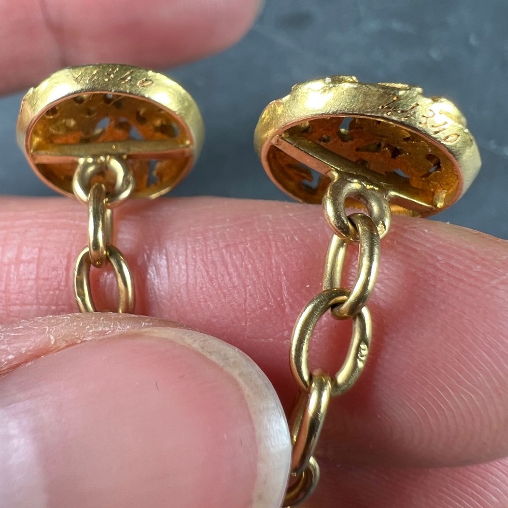 A pair of circular 18-carat yellow gold Art Nouveau cufflinks featuring pierced openwork mistletoe leaf motifs connected by chain links. View XI