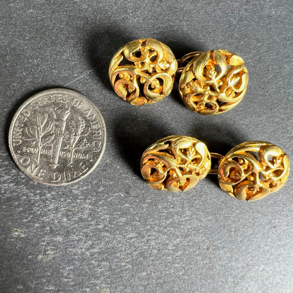 A pair of circular 18-carat yellow gold Art Nouveau cufflinks featuring pierced openwork mistletoe leaf motifs connected by chain links. View XIII