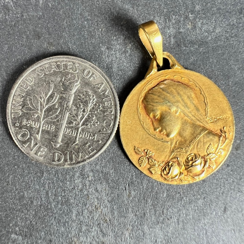 A circular 18-carat yellow gold pendant featuring a profiled relief of the Virgin Mary adorned with floral motifs. View X