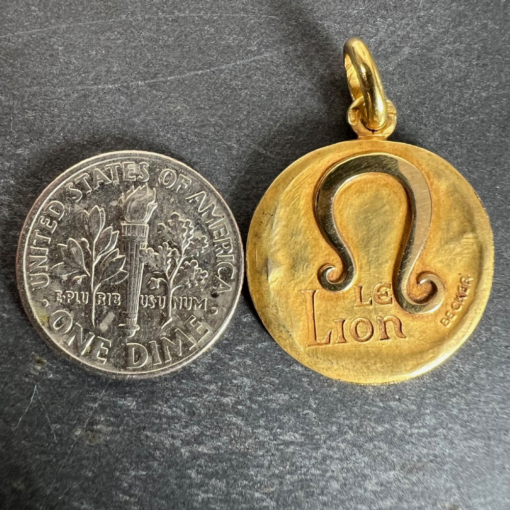 A circular 18ct yellow gold pendant featuring a relief Leo zodiac symbol above engraved text reading Le Lion and maker mark Becker. View X