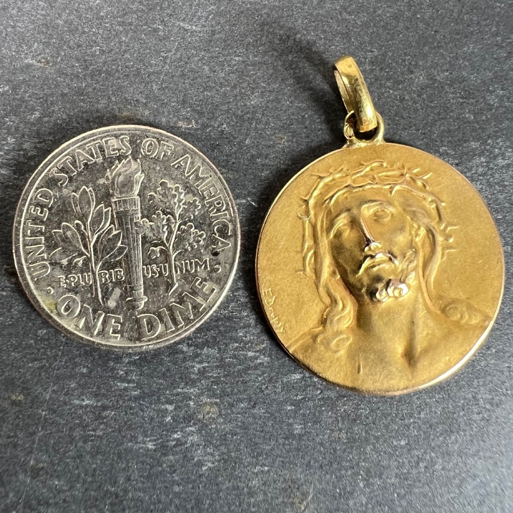 A circular 18ct yellow gold religious medallion depicting the relief profile of Jesus Christ wearing a crown of thorns, signed by E. Dropsy. View X