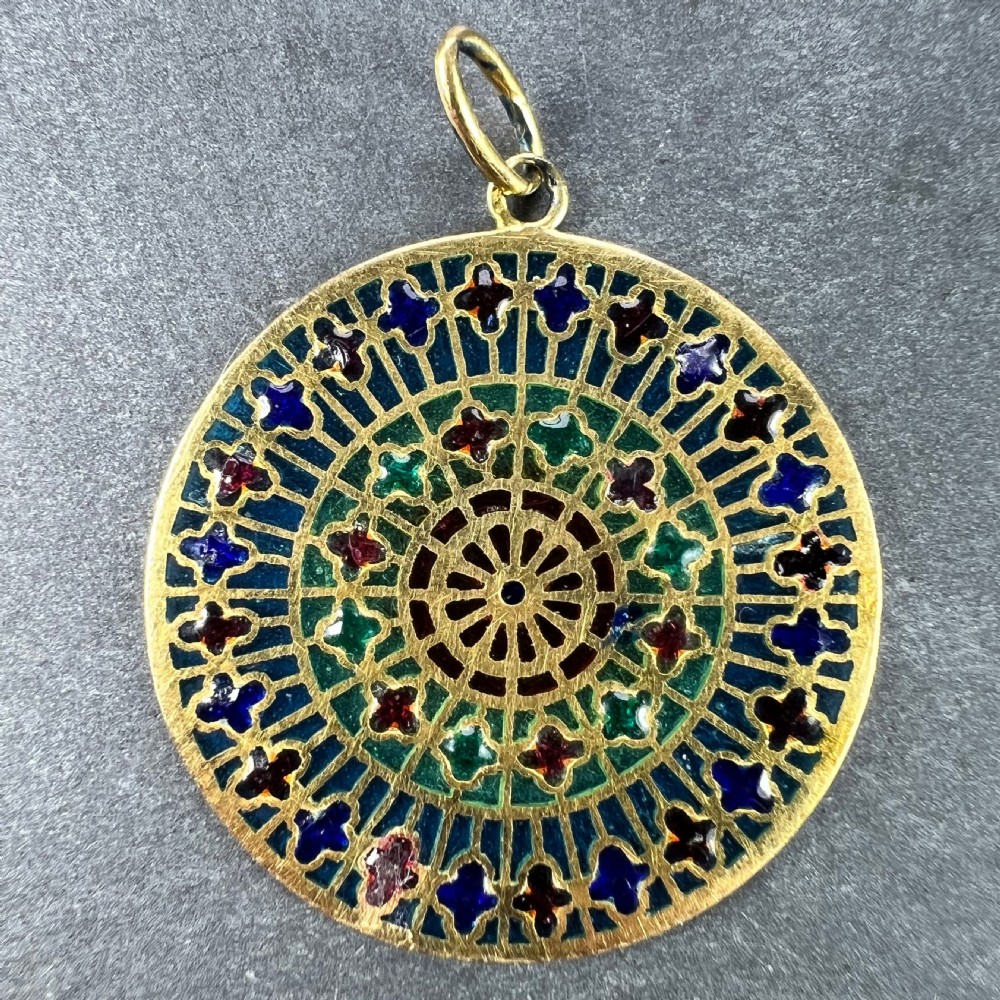 A circular 18k yellow gold pendant featuring translucent plique-a-jour enamelling in a geometric cathedral rose window motif. View VII
