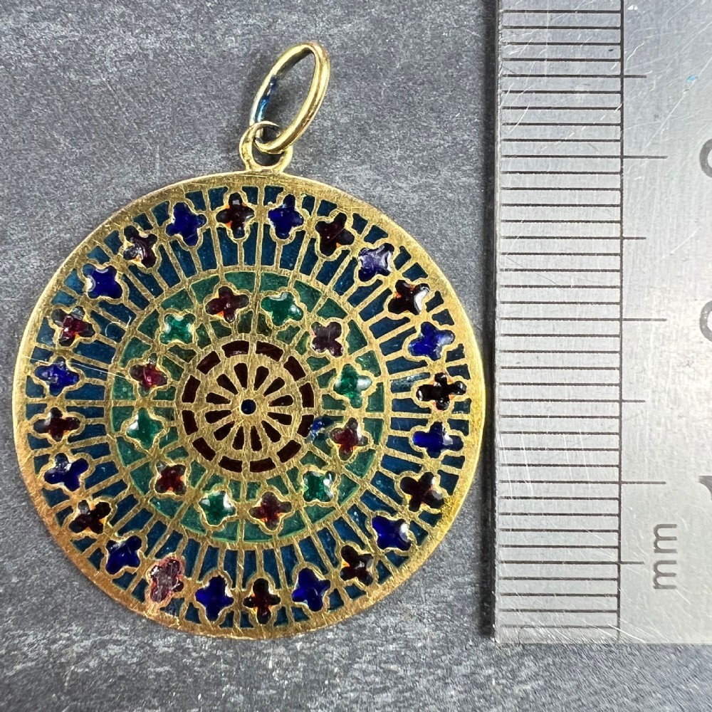 A circular 18k yellow gold pendant featuring translucent plique-a-jour enamelling in a geometric cathedral rose window motif. View XV
