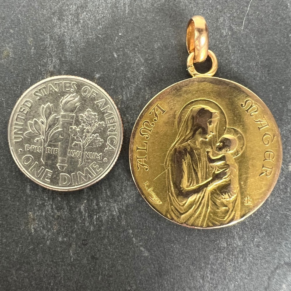 A circular 18ct yellow gold medal pendant featuring a bas-relief depiction of the Madonna holding the Christ Child with the Latin words Alma Mater engraved along the edge. View XIV