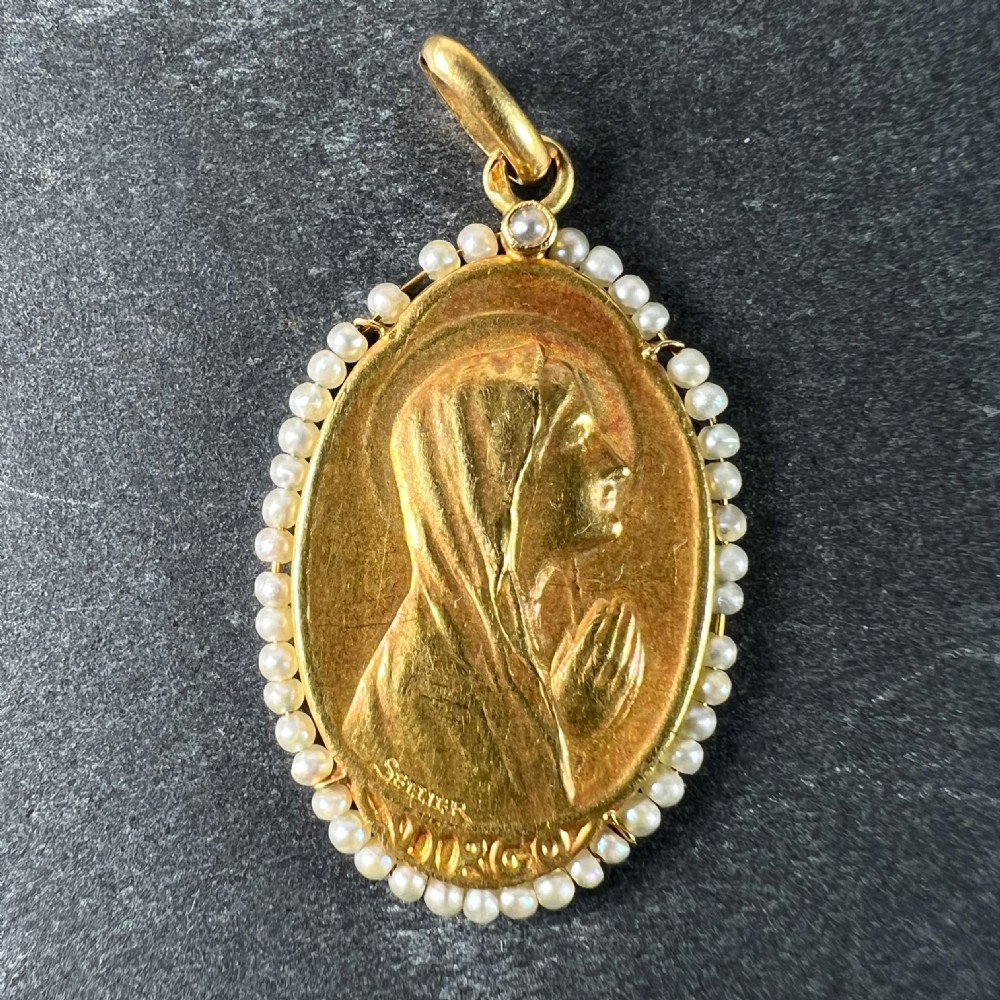 An oval 18ct yellow gold religious pendant depicting the Virgin Mary in profile, bordered by small seed pearls. View II