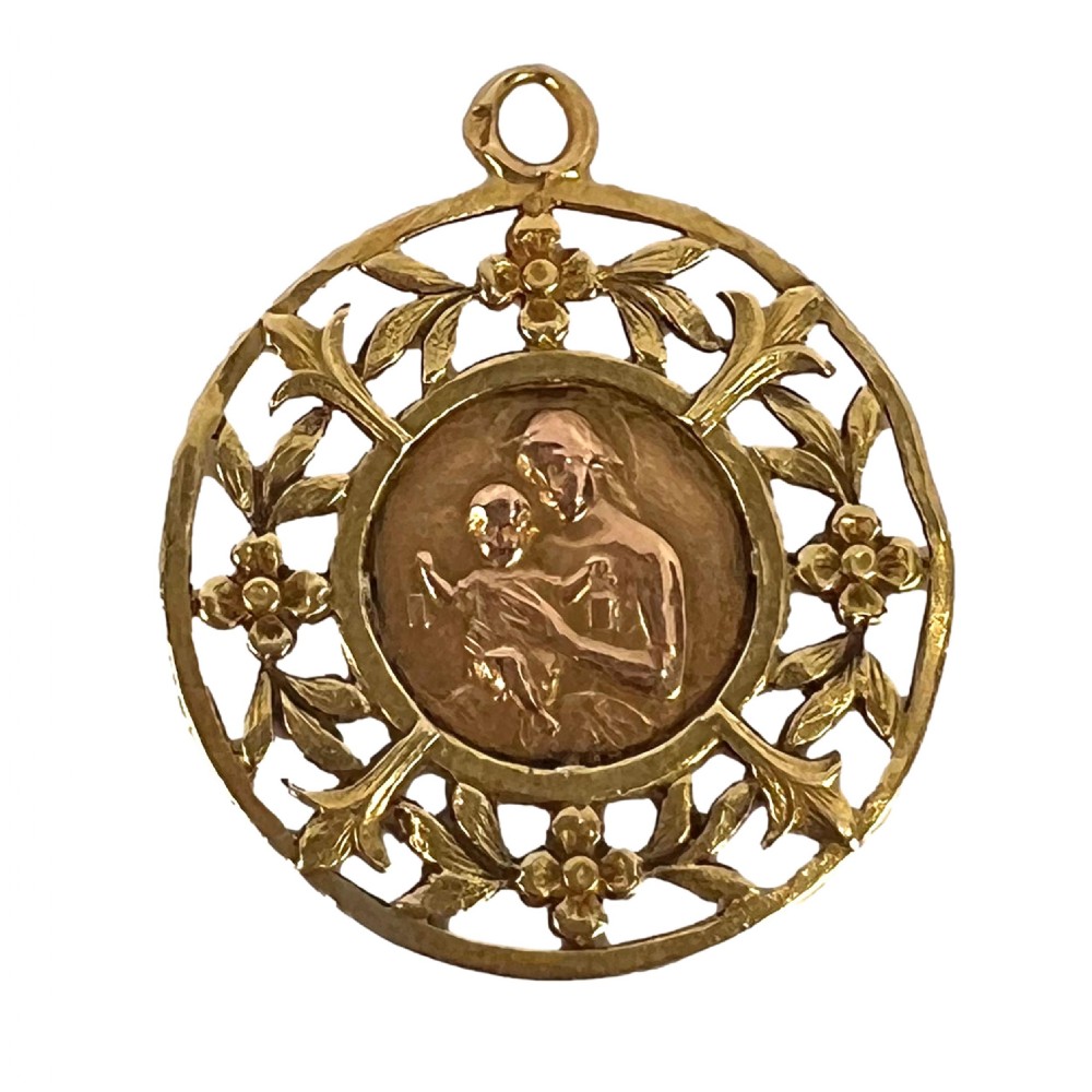A circular 18-carat yellow gold religious pendant depicting the Madonna and Child in relief surrounded by an intricate openwork floral border. View XIV