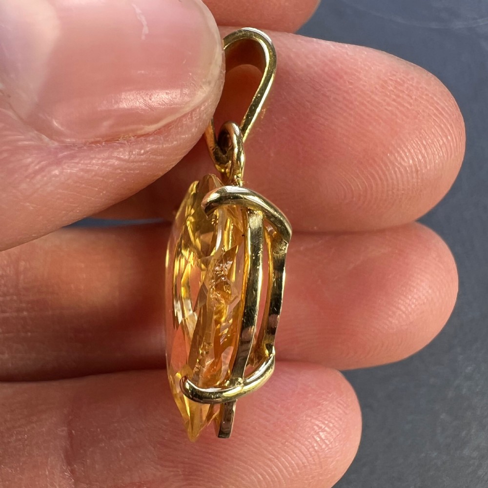A heart-shaped faceted yellow citrine gemstone set in an eighteen-carat yellow gold claw mount with a top loop. View VII