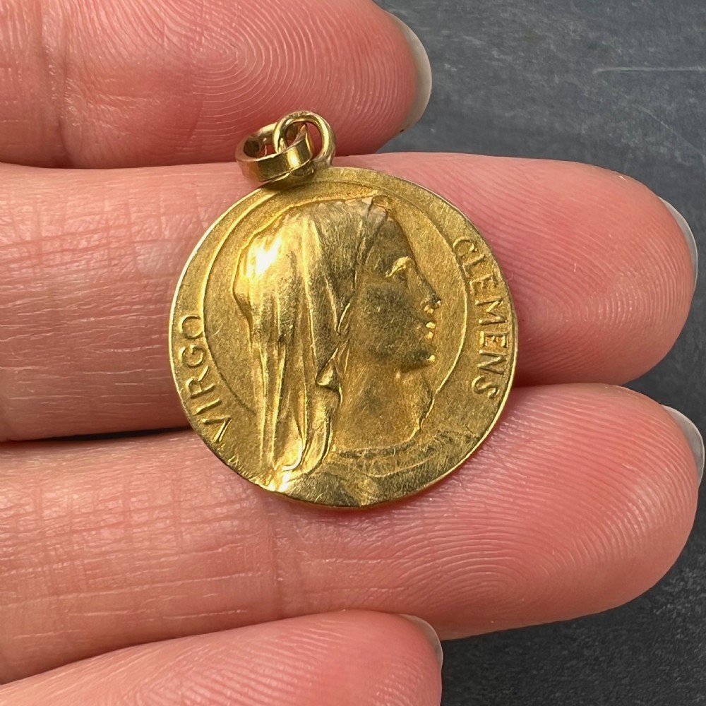 A circular 18K yellow gold medal featuring a relief profile of the veiled Virgin Mary surrounded by the Latin inscription Virgo Clemens. View V
