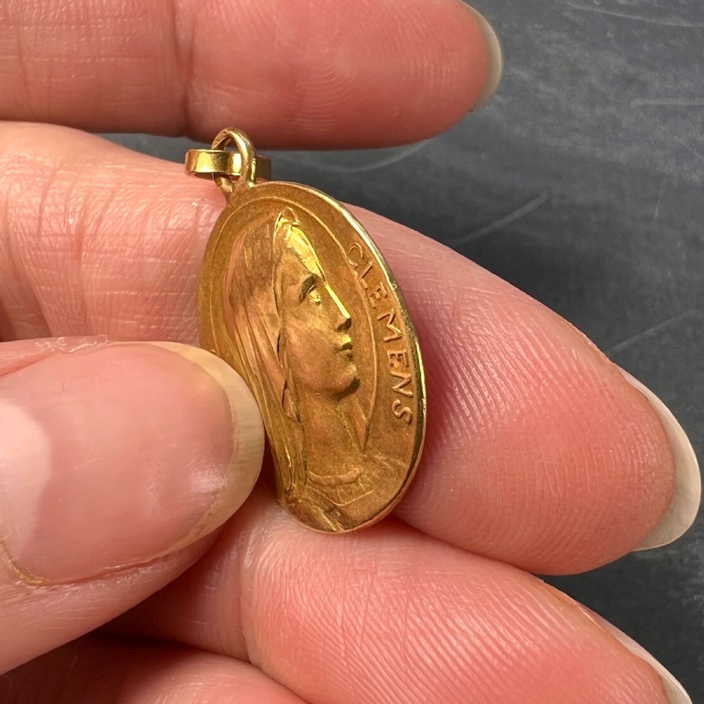 A circular 18K yellow gold medal featuring a relief profile of the veiled Virgin Mary surrounded by the Latin inscription Virgo Clemens. View VI