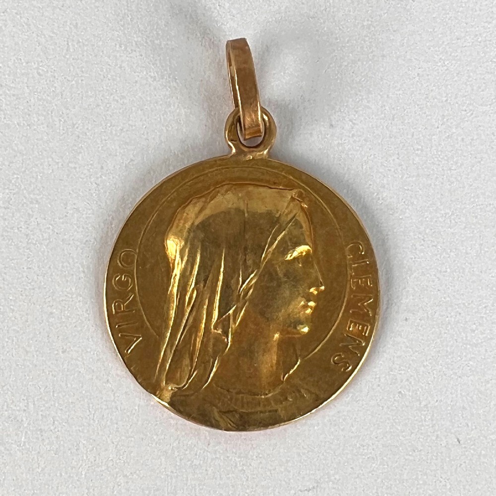 A circular 18K yellow gold medal featuring a relief profile of the veiled Virgin Mary surrounded by the Latin inscription Virgo Clemens. View X