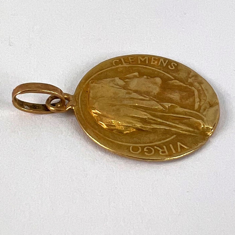 A circular 18K yellow gold medal featuring a relief profile of the veiled Virgin Mary surrounded by the Latin inscription Virgo Clemens. View XII