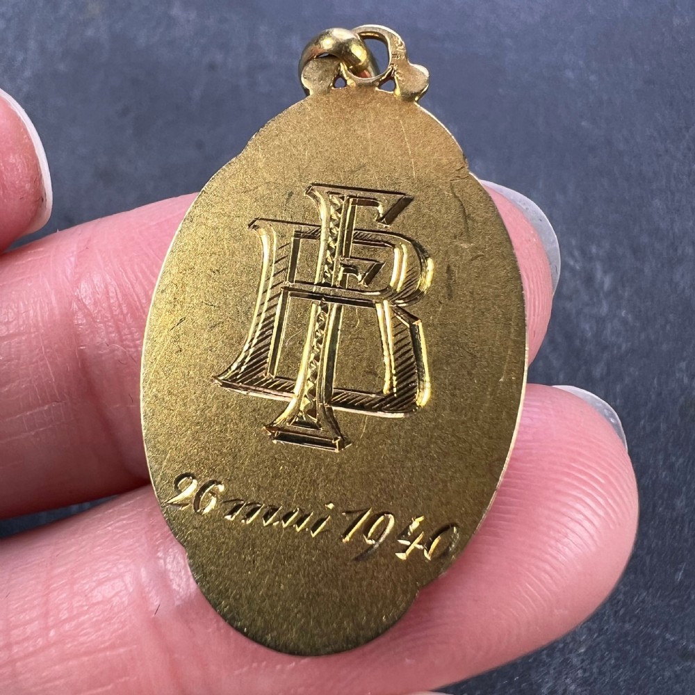 An oval 18k yellow gold religious medal depicting a profile bas-relief of the Virgin Mary in prayer with the inscription Virgo and signature Sellier. View VIII