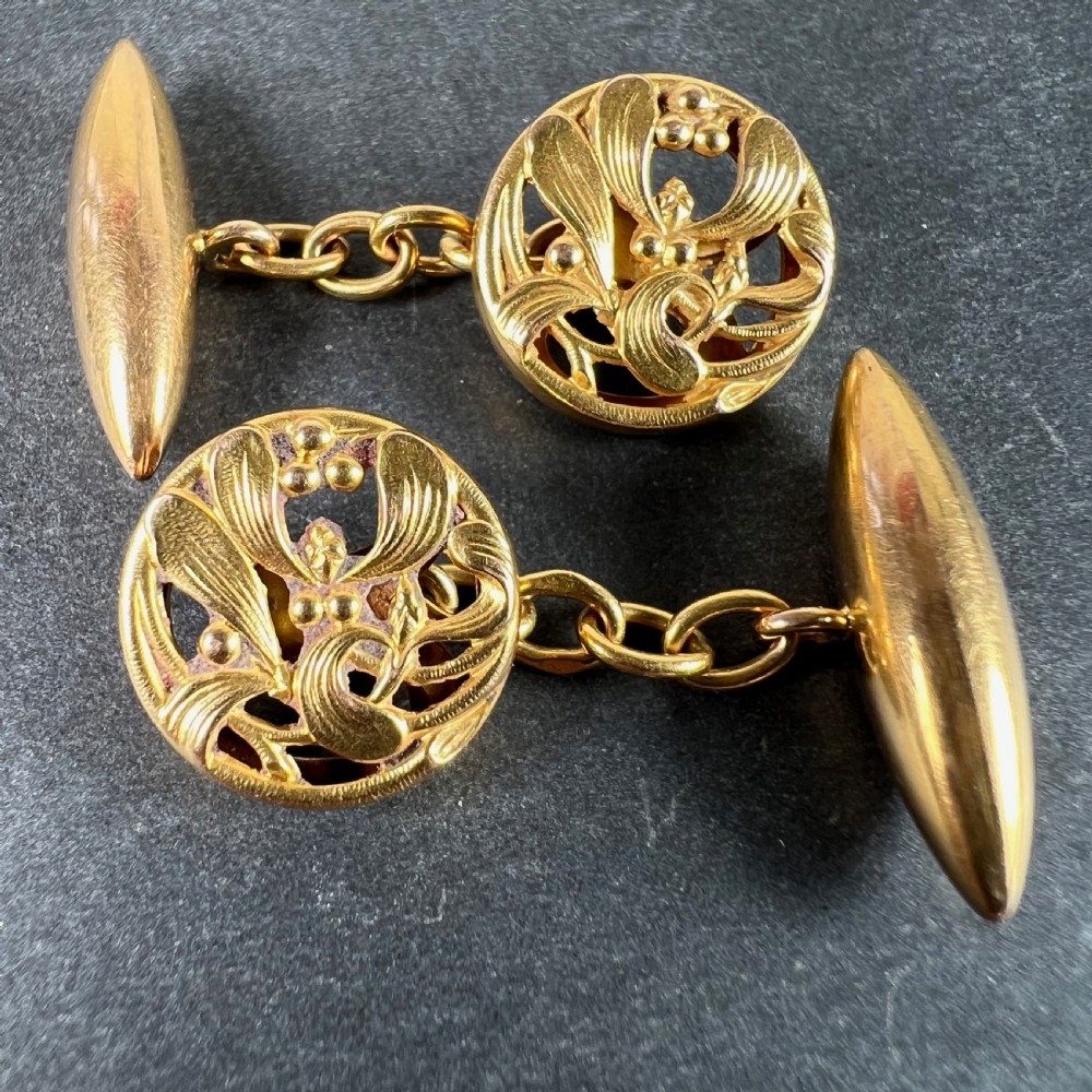 A pair of circular 18ct yellow gold Art Nouveau cufflinks featuring pierced mistletoe foliage linked by chain to torpedo-shaped backs. View III