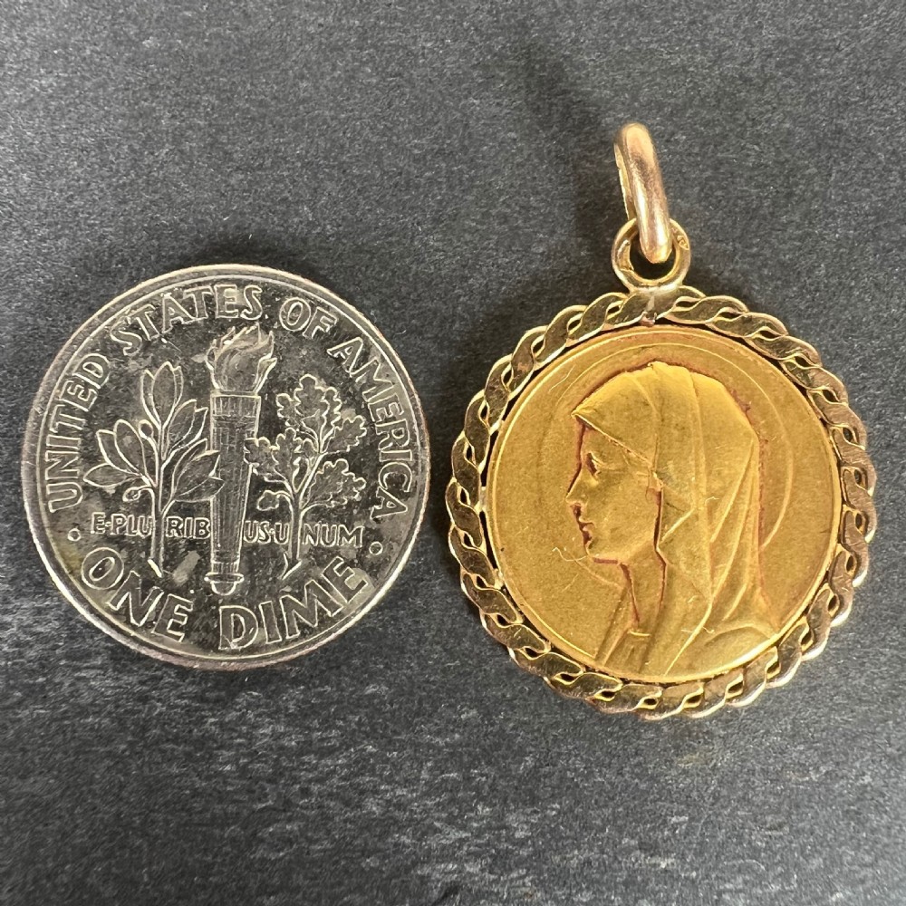 A circular 18-carat yellow gold medallion featuring a bas-relief side profile of the Virgin Mary surrounded by a braided border. View XI