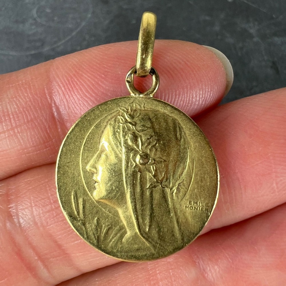 A circular 18k yellow gold pendant featuring a relief profile portrait of the Virgin Mary signed by Emile Monier. View V