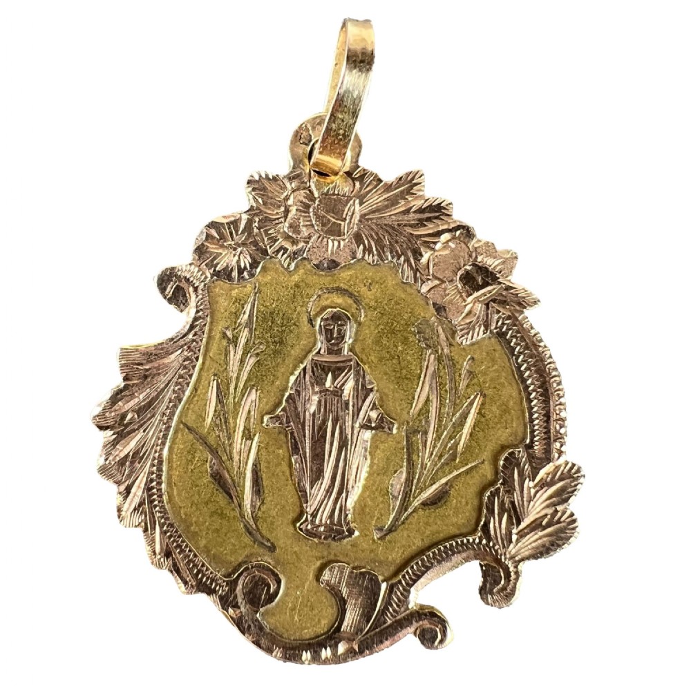 An antique French 18K yellow and rose gold religious pendant featuring an engraved Virgin Mary surrounded by a textured floral border.