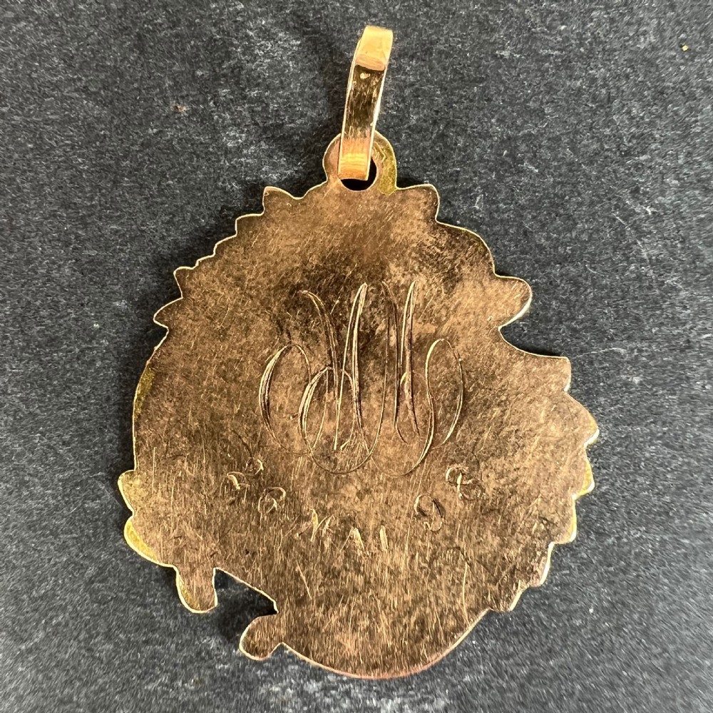 An antique French 18K yellow and rose gold religious pendant featuring an engraved Virgin Mary surrounded by a textured floral border. View III