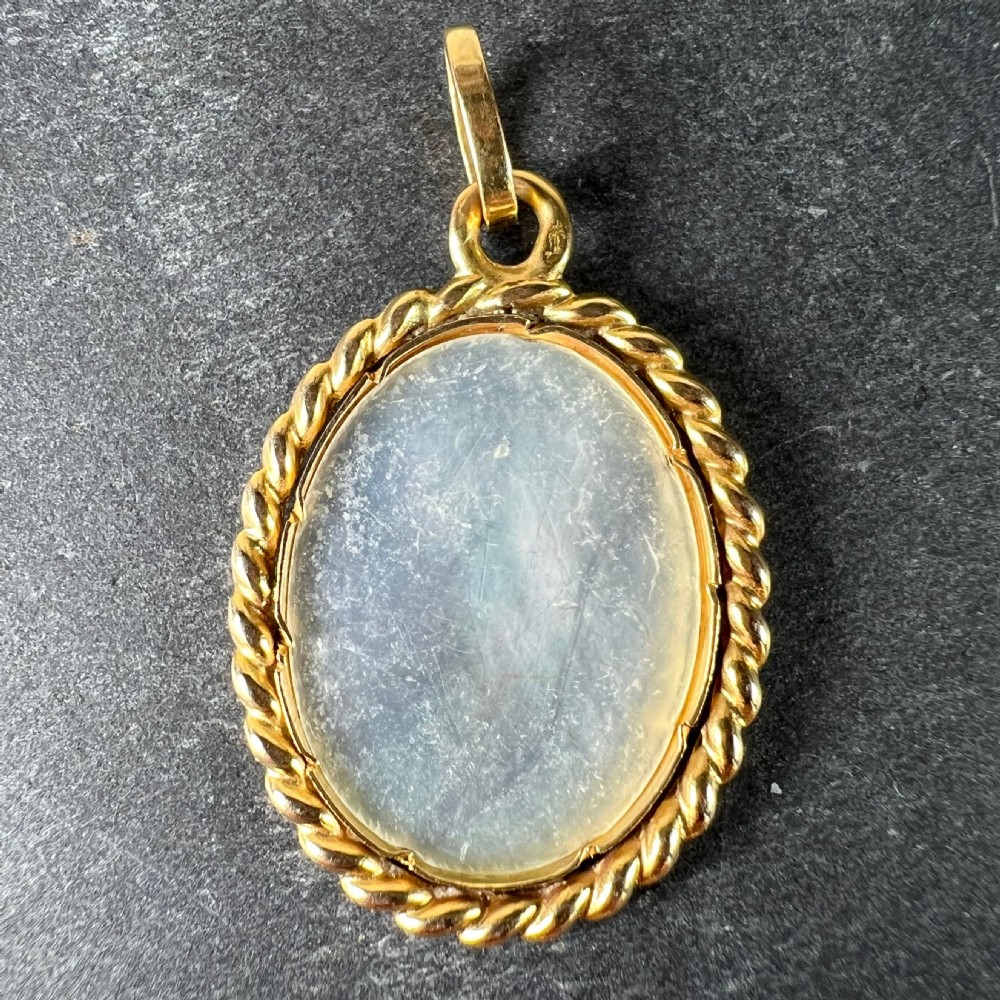 An oval mother-of-pearl charm set in an 18-carat yellow gold frame with a twisted wire border. View III