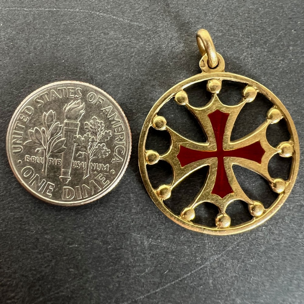 A circular 18ct yellow gold pendant featuring a central red enamelled cross surrounded by an openwork rim with small spherical accents. View XI