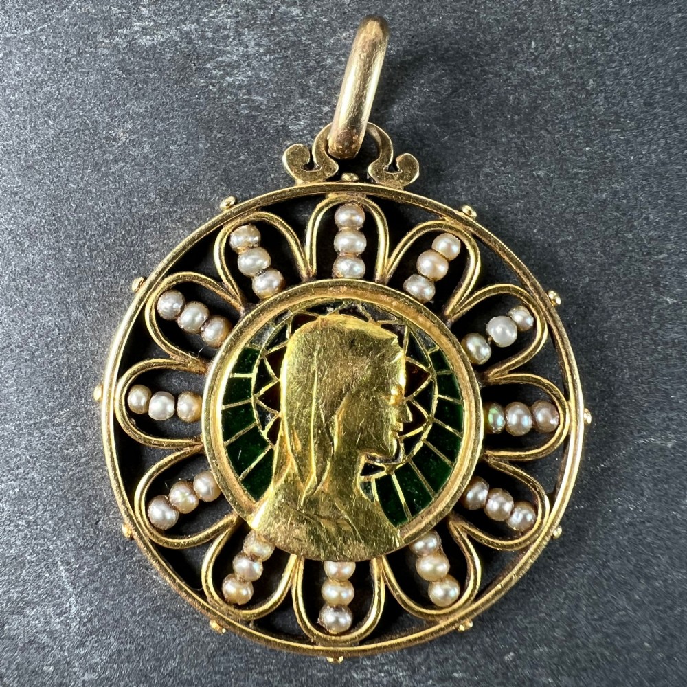 A circular 18K yellow gold pendant featuring a central profile bust of the Virgin Mary framed by green and red translucent plique-a-jour enamel and a outer ring of seed pearls set in wirework loops. View VII