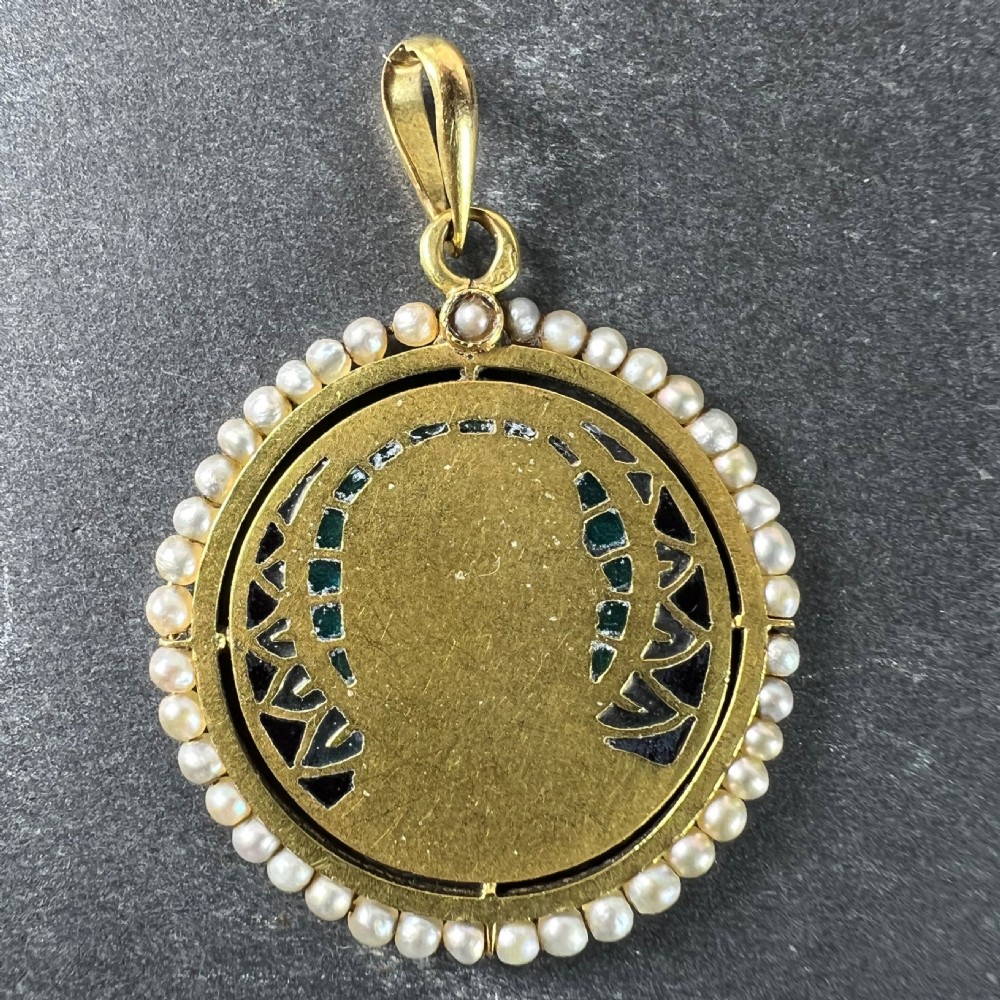An 18k gold circular pendant featuring a sculpted profile of the Virgin Mary surrounded by translucent blue and green plique-a-jour enamel and framed by seed pearls. View VI
